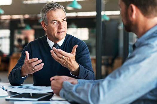 Photograph depicting two colleagues meeting in a modern office