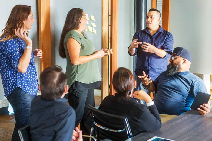 Photograph of an office meeting between six colleagues
