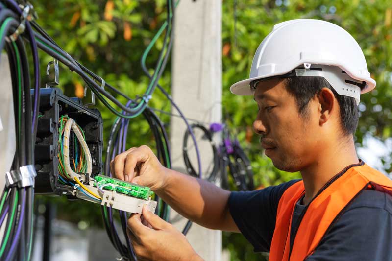 Photograph of an electrician servicing an electrical board