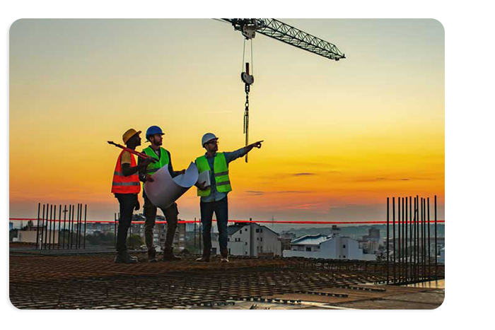 Photograph of three construction workers standing on an uncompleted structure