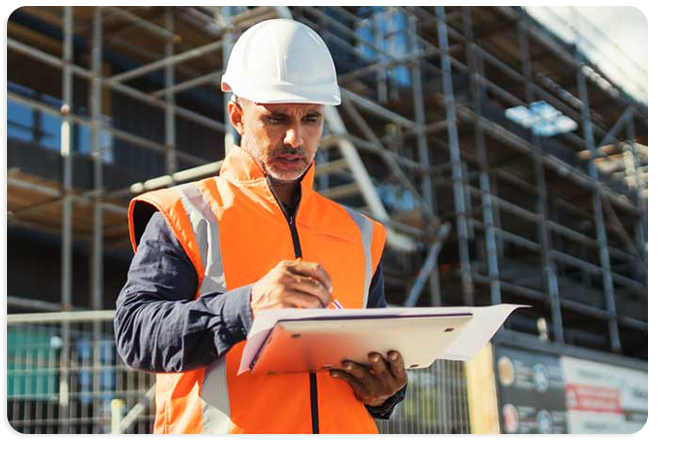 Photograph of a contruction worker holding a laptop ensuring contractor safety culture