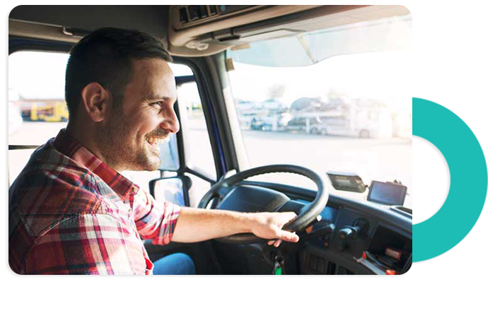 Photograph of a truck driver gripping the steering wheel of their vehicle taken from inside the cab
