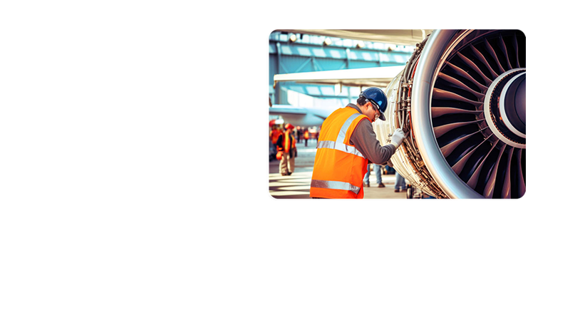 A photograph of a technician wearing a high vibility vest and hard hat servicing a large aircraft engine